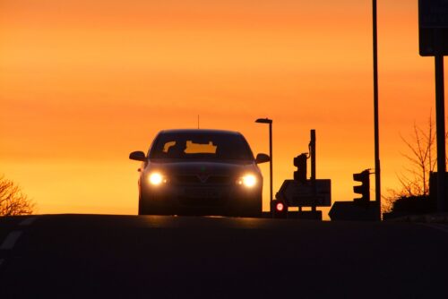 夕日を背に受けて走る車の写真