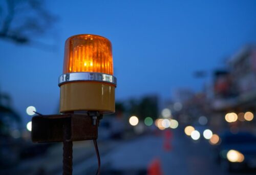 夜の街に光る黄色い回る警告ランプのイメージ画像