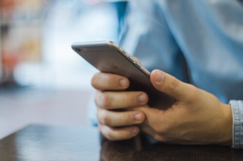 スマホを持ち、友達に電話をかけようとしているイメージ画像
