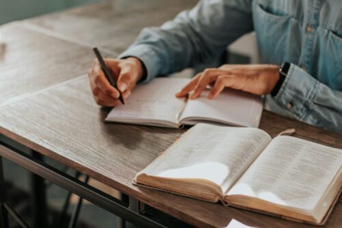机の上に広げられたノートで今だ勉強中のイメージ画像
